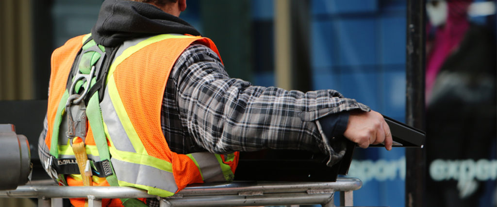 Construction worker using an aerial lift on a commercial job site, highlighting construction safety and third-party liability risks in Washington.