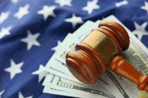 A gavel sits on top of a stack of us dollar bills. - Olympia Catastrophic Injury Lawyer