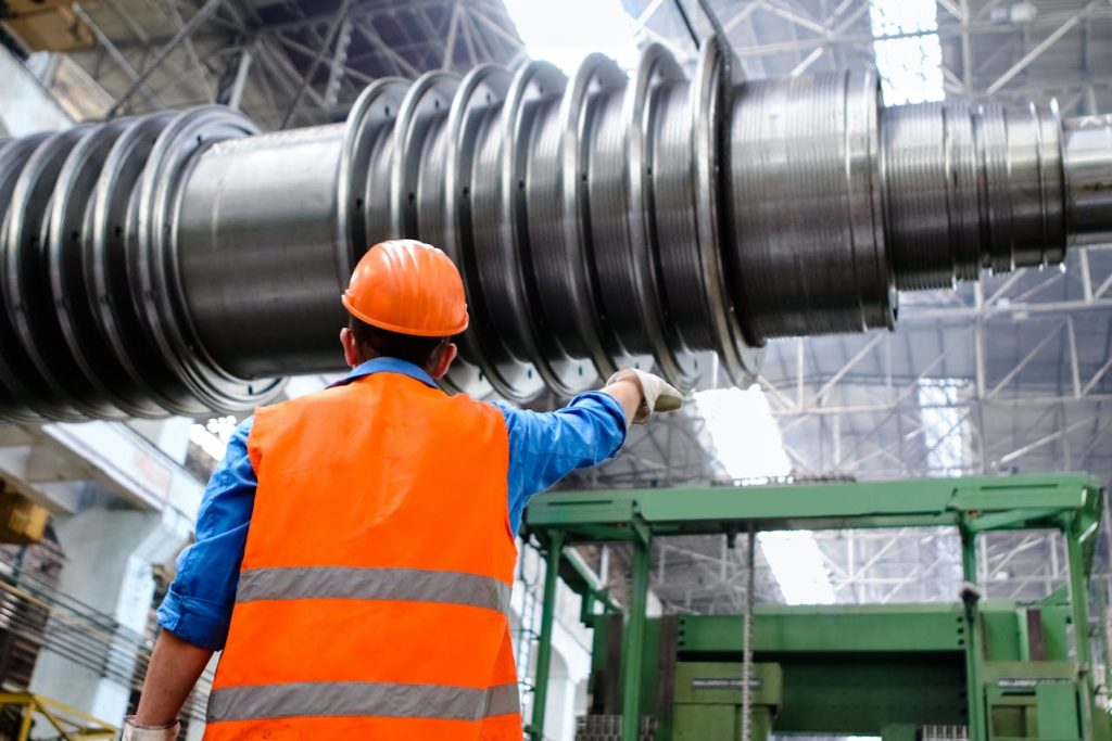 a man in an orange safety vest working on a large pipe - Washington Attorneys Advocate