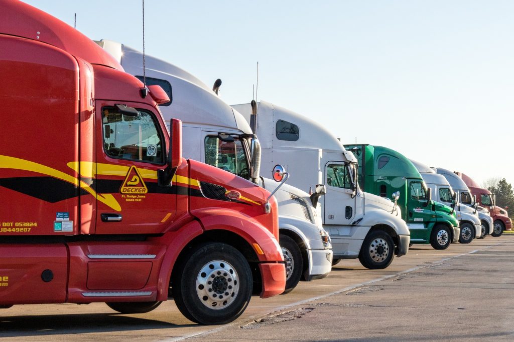 a row of semi trucks parked next to each other - Commercial Vehicle Accident