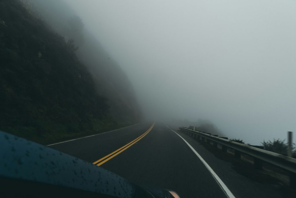 a car driving down a road on a foggy day - Car Accident Liability