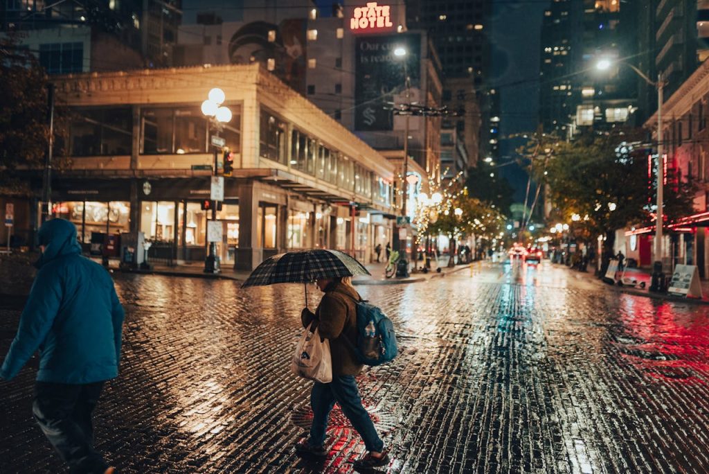 a woman walking down a street holding an umbrella - Pedestrian Accidents in Washington