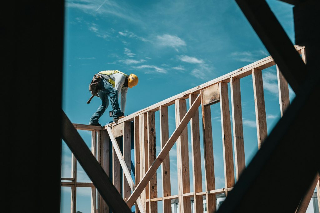 Construction worker framing a building while following safety procedures to reduce the risk of fatal construction site accidents in Washington.
